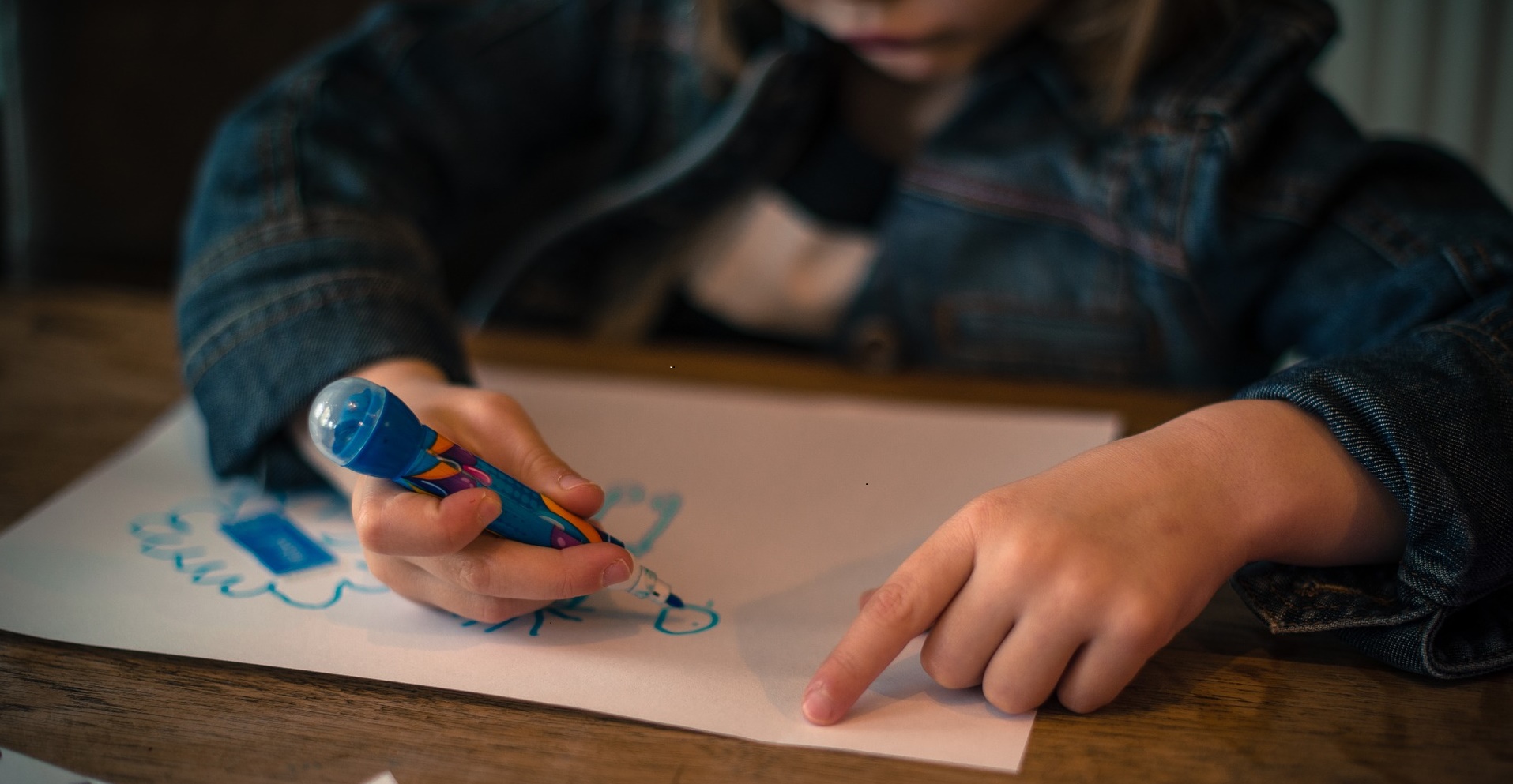 Requisitos para acogimiento familiar Plano de las manos de un niña dibujando sobre un papel