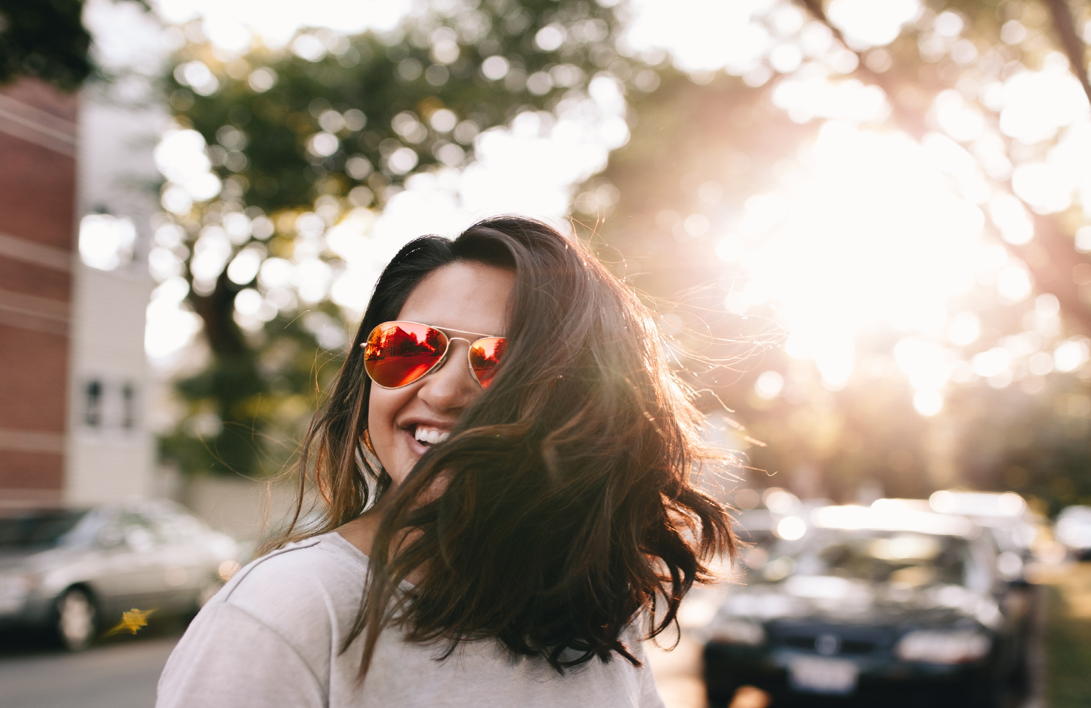 Información Juvenil Chica con gafas de sol y pelo suelto sonriendo