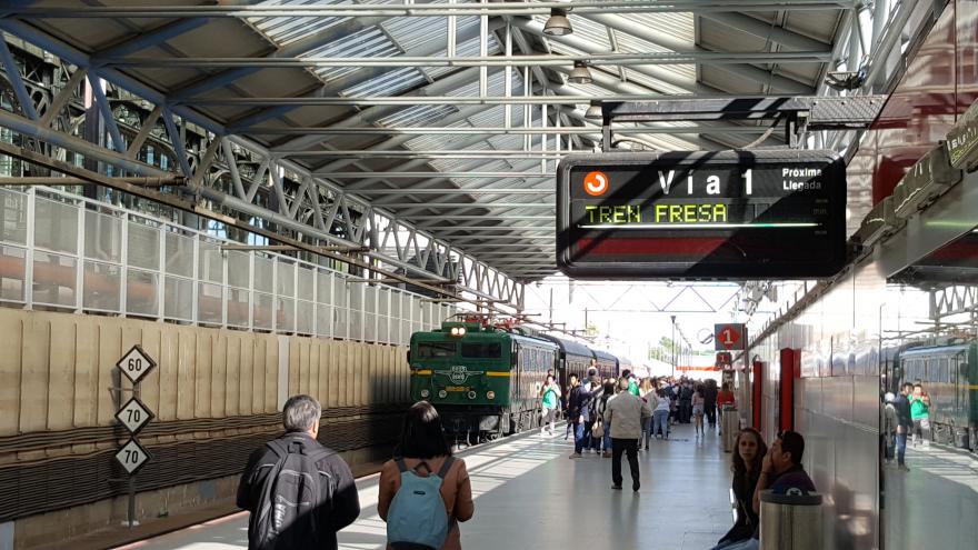 Andén en una estación con el Tren de la Fresa a puto de partir