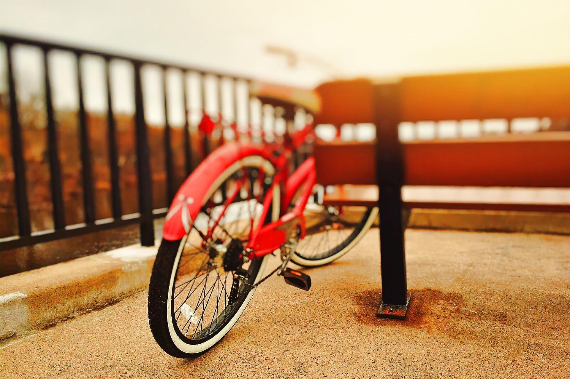 Deporte y actividades en los parques Bicicleta roja apoyada en un banco
