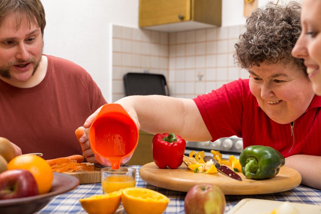 Mujer con discapacidad preparando un desayuno con zumo Mujer con discapacidad preparando un desayuno con zumo en un centro