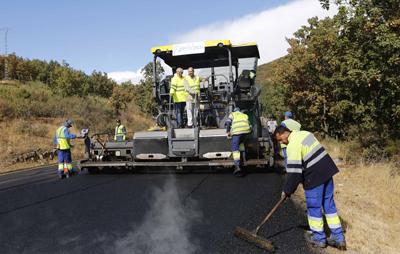 Obras refuerzo en la M-601 obreros trabajando con maquinaria asfaltando en la M-601