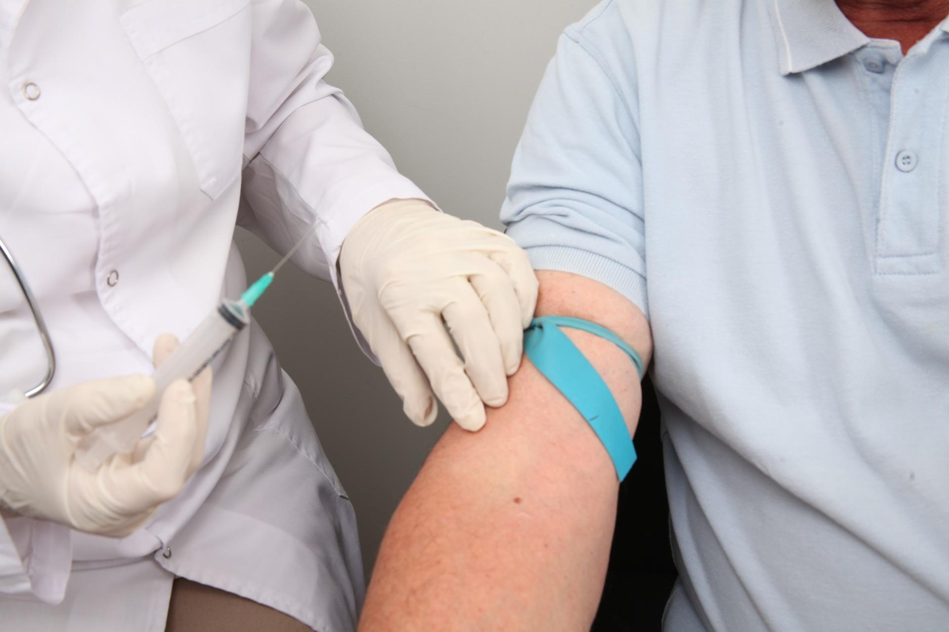 Inoculación accidental Imagen de un médico con una jeringuilla en la mano preparado para sacar sangre