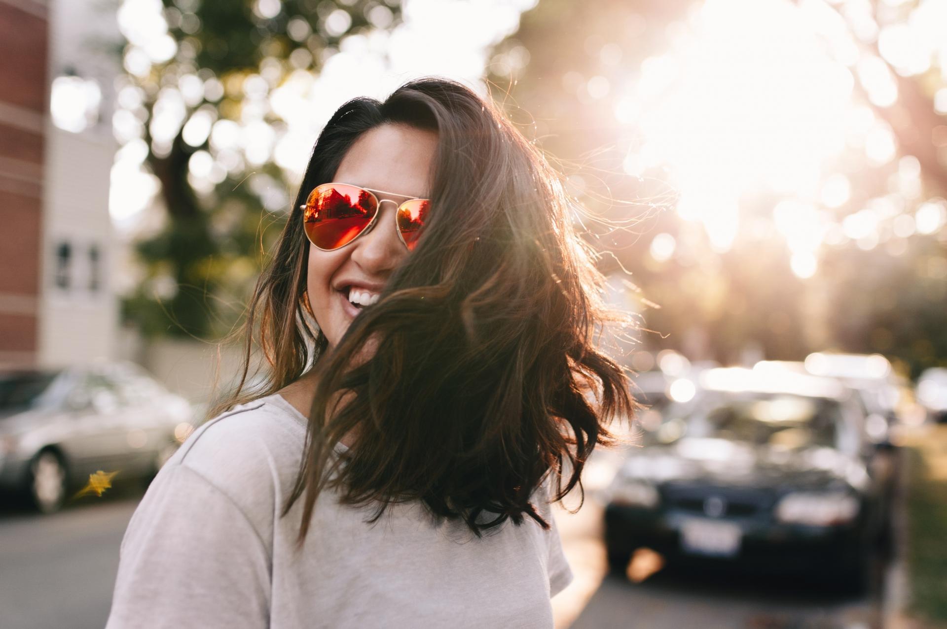 Información juvenil Chica con gafas de sol y pelo suelto sonriendo