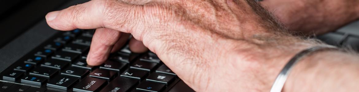 Universidad para mayores Primer plano de las manos de un hombre mayor sobre teclado de ordenador portátil