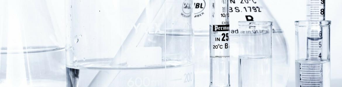 Registro de laboratorios Imagen de matraces y pipetas transparentes en la mesa de un laboratorio