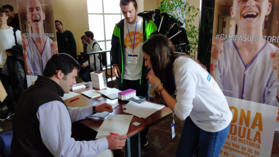 jóvenes sentados informándose sobre el registro como donante de médula