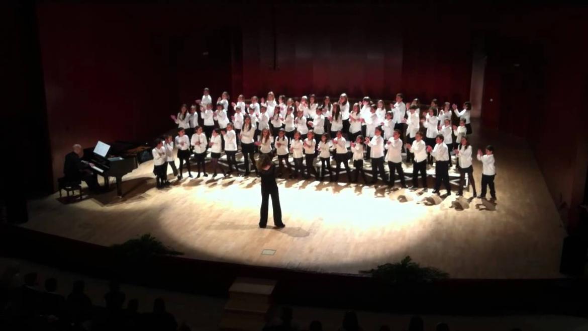 Coro de niños cantando sobre un escenario