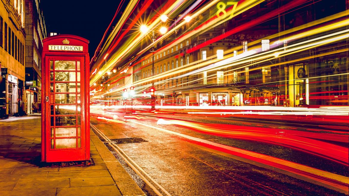 Implantación de proyectos bilingües Cabina de teléfonos típicamente inglesa con luces de tráfico de la calle en la noche