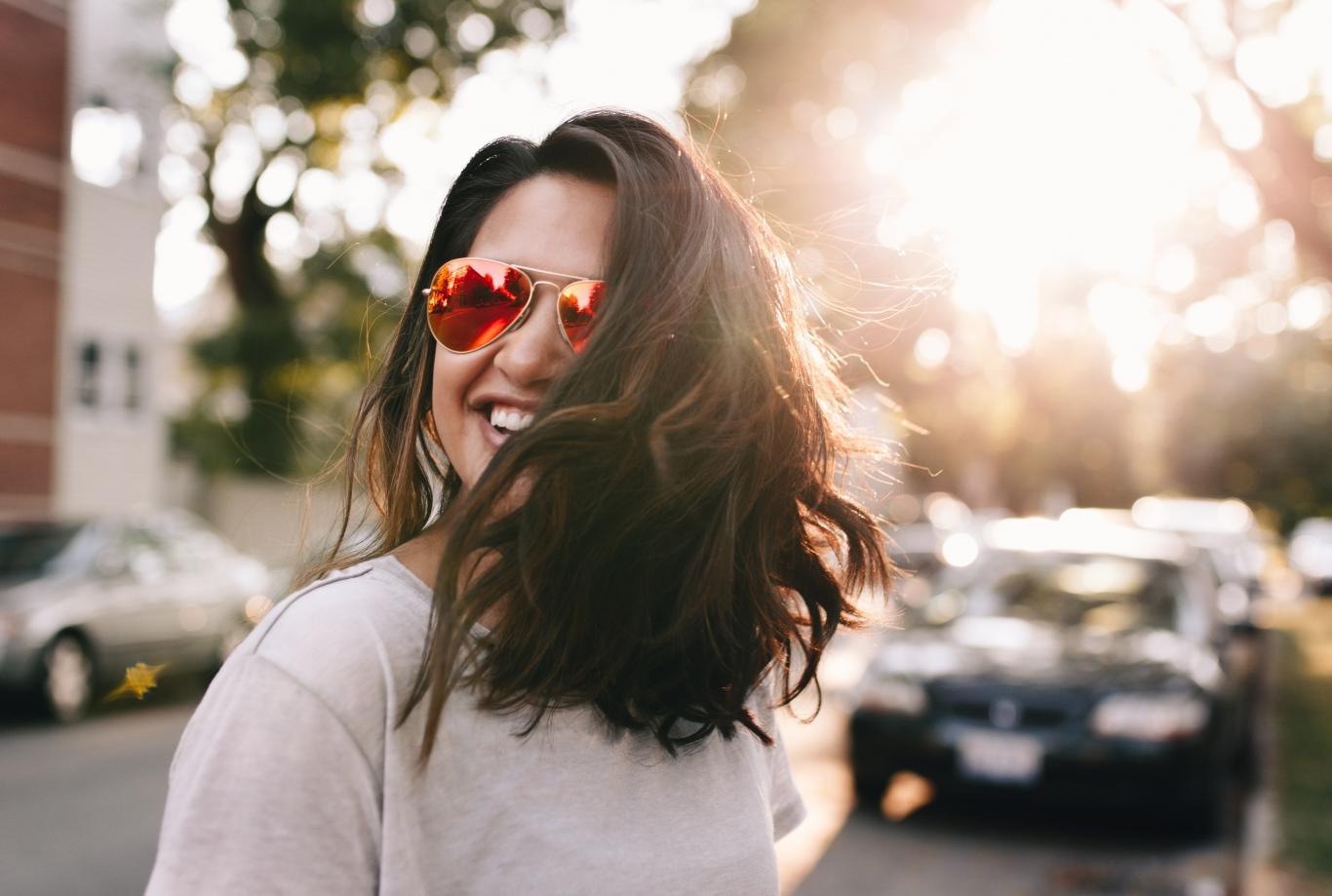 Información juvenil Chica con gafas de sol y pelo suelto sonriendo