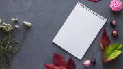 cuaderno con hojas y flores alrededor