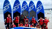 Grupo de jóvenes con chalecos y tablas para hacer surf