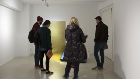 Grupo de gente joven observando una obra de arte contemporánea