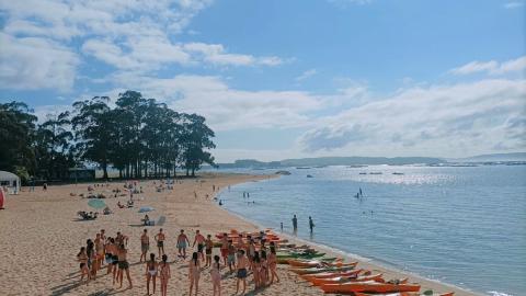 Vistas de una playa con grupo de jóvenes para ir en piragua