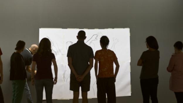 Taller con jóvenes y artistas Grupo de gente joven observando un lienzo en blanco en una sala de exposiciones