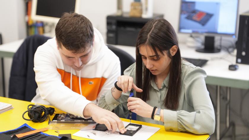 Talleres pre-laborales discapacidad Dos jóvenes con discapacidad en un taller de reparación de móviles