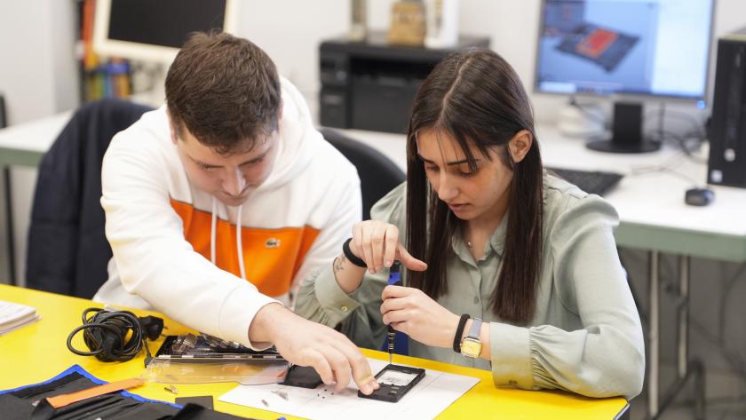 Talleres pre-laborales discapacidad Dos jóvenes con discapacidad en un taller de reparación de móviles