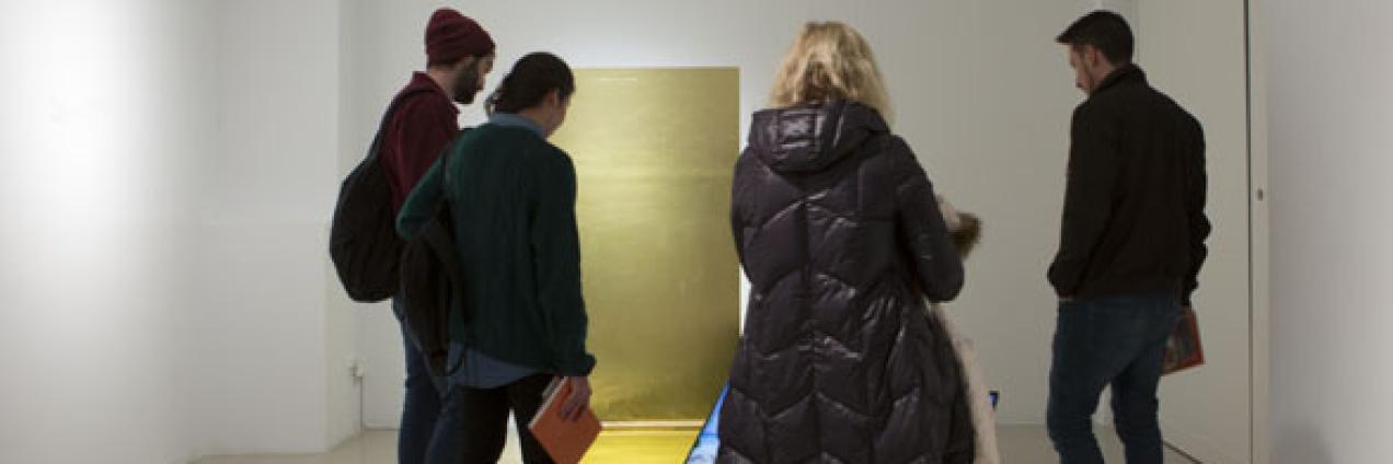 Grupo de gente joven observando una obra de arte contemporánea