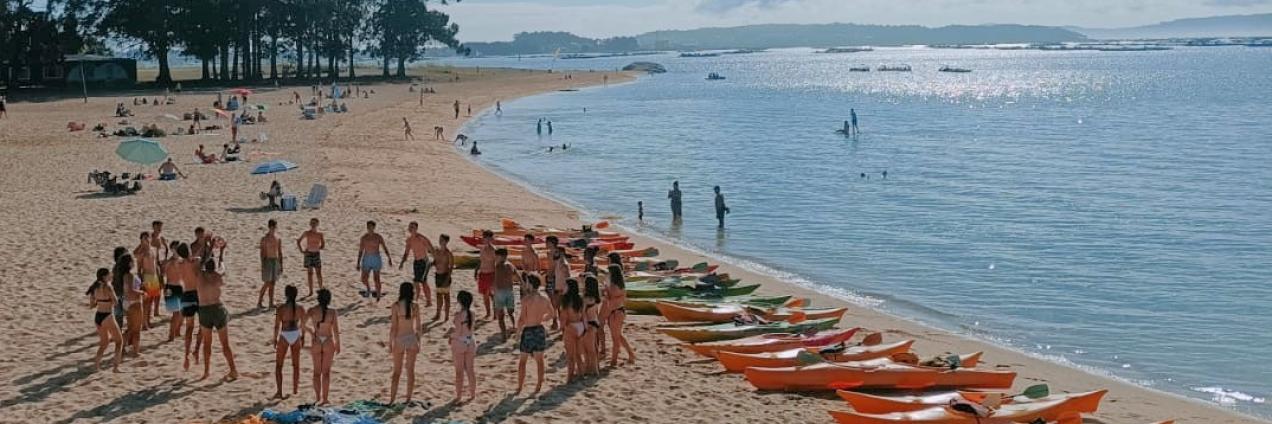 Vistas de una playa con grupo de jóvenes para ir en piragua