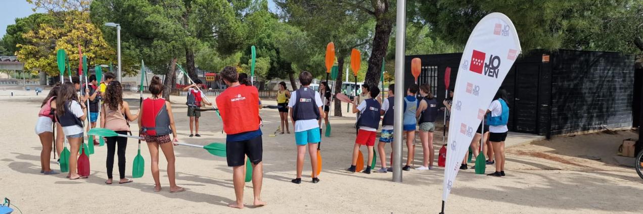 Jóvenes de pie en un parque con las palas de piragüas