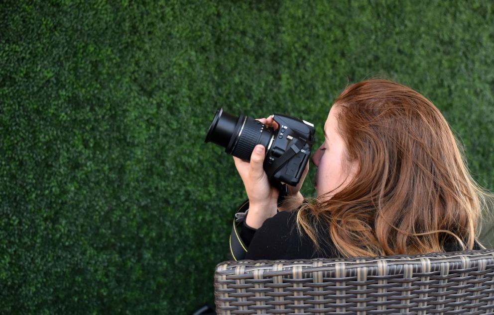 Chica sentada haciendo fotos con una cámara
