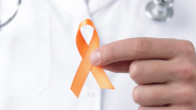 Esclerosis múltiple mano de doctor cogiendo un lazo naranja