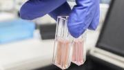 mano sosteniendo dos tubos de ensayo de laboratorio