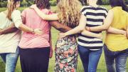 Varias mujeres de espaldas en línea abrazadas por la cintura