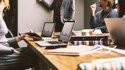 ¿Hablamos de clima laboral o de evaluación de riesgos psicosociales? Foto reunión mesa trabajo con ordenadores