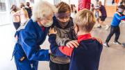 Varios niños con los ojos vendados simulando una actividad deportiva para personas con discapacidad