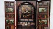 armario relicario de madera con una imagen central y una serie de pequeñas imágenes en cada puerta del armario