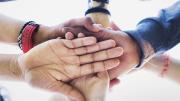 Conjunto de personas uniendo sus manos en un gesto de unión