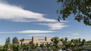 Vista con nubes y árboles de la fachada del Hospital público de Getafe