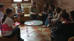 Jóvenes alrededor de mesa haciendo dinámica con cartulina