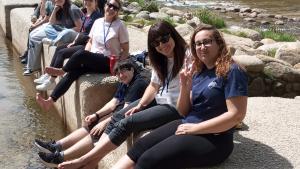 jóvenes sentados en pasarela de río