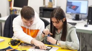 Dos jóvenes con discapacidad en un taller de reparación de móviles