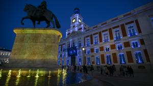 La fachada de la Real Casa de Correos iluminada de azul