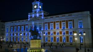 La fachada de la Real Casa de Correos iluminada de azul