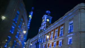 La fachada de la Real Casa de Correos iluminada de azul