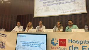 Personas en una mesa presidencial en un salón de actos durante un acto institucional