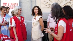 La presidenta Isabel Díaz Ayuso en una mesa informativa de Cáritas Diocesana