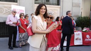 La presidenta Isabel Díaz Ayuso en una mesa informativa de Cáritas Diocesana