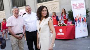 La presidenta Isabel Díaz Ayuso en una mesa informativa de Cáritas Diocesana