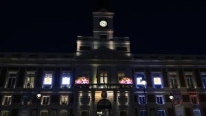 Fachada de la Real Casa de Correos iluminada por la visita del Papa