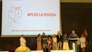 Agentes implicados en el APS premiado subidos en el escenario recogiendo el diploma y escuchando hablar al director del IES La Poveda