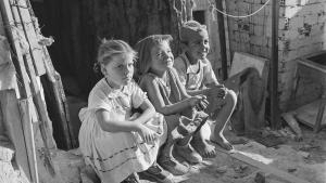 Un grupo de niños sentados en la entrada de una chabola