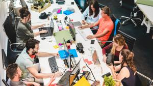 Grupo de personas jóvenes trabajando alrededor de una mesa