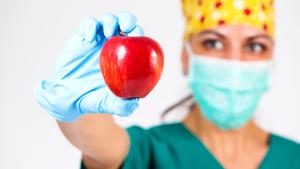 Un profesional sanitario con una manzana en la mano