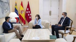 La presidenta sentada en unos sofás con una mesa en medio y a su lado izquierdo sentado Leopoldo López y al derecho Enrique López  