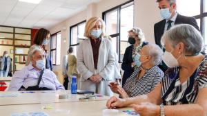 La consejera hablando con personas mayores sentadas en una mesa